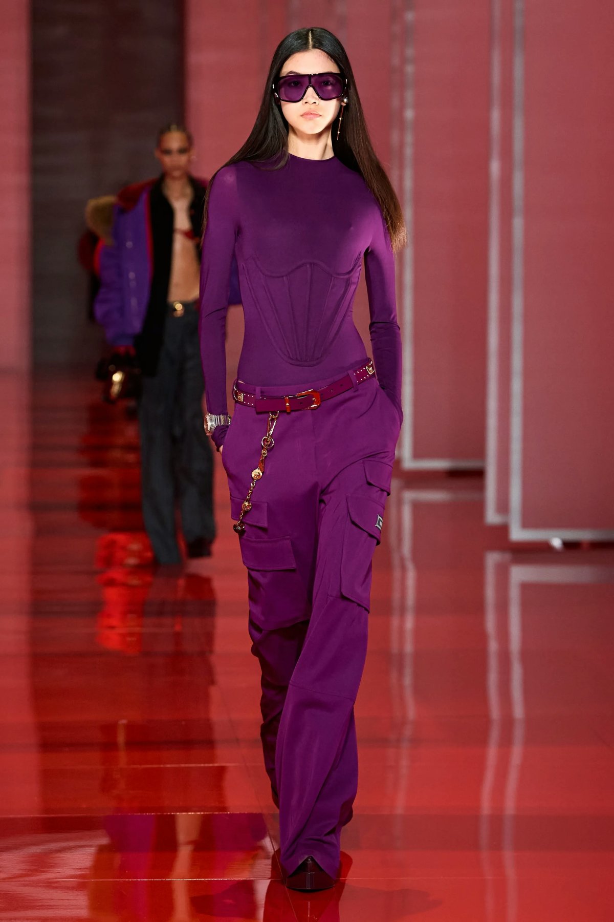 Model walking on the Versace Fall/Winter 2022 runway show while wearing a purple-shade glasses and purple outfit