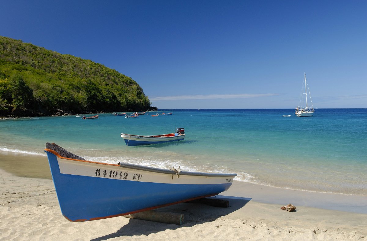 blue boat on a beach blue water blue sky