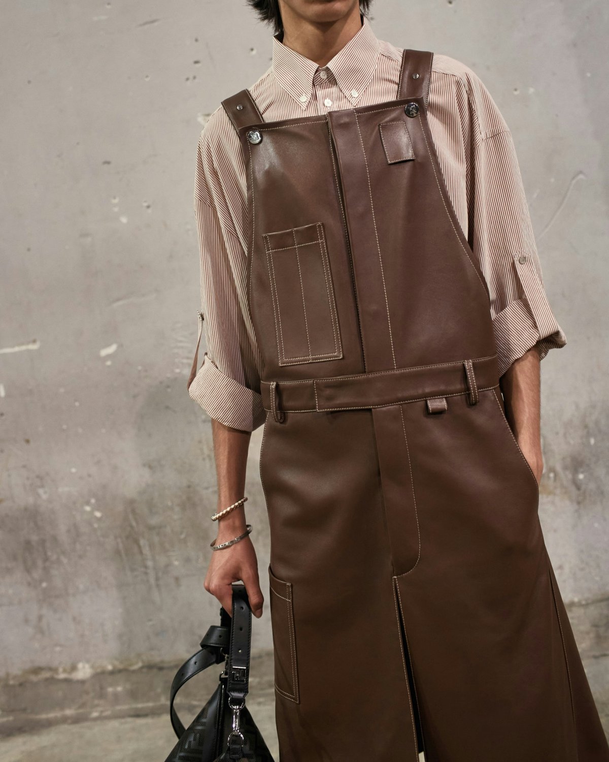 A mdoel in a leather oversized jumpsuit.