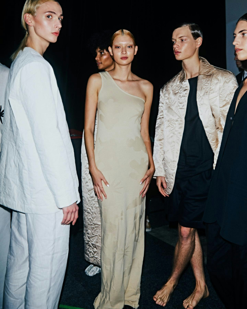 Four models standing in runway clothes. Photo via Instagram/ @ausfashionweek