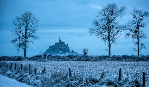 abbey and field in winter covered by snow