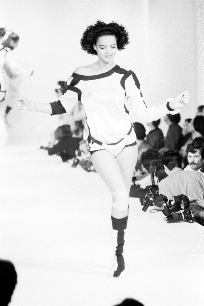 model on runway in white shirt and knee pads