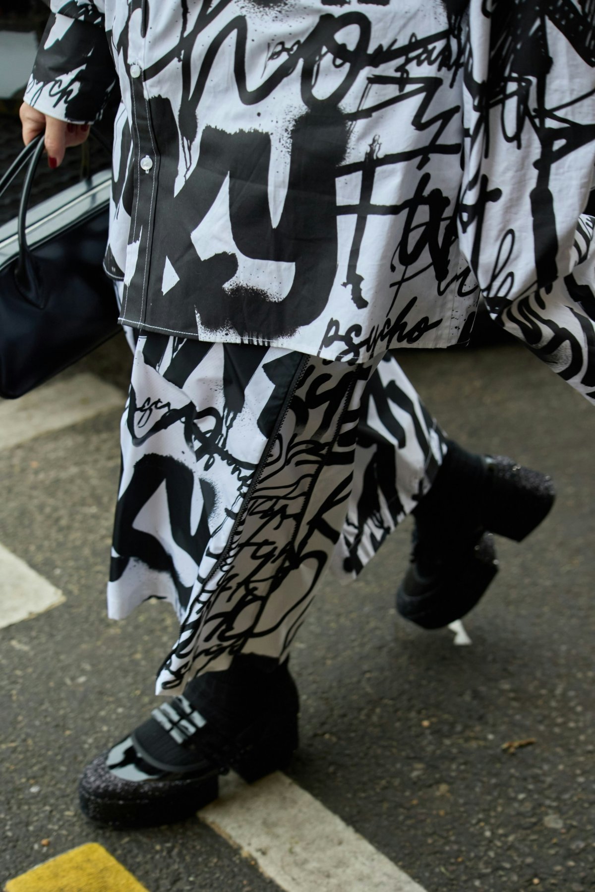 footwear shoe person walking road tarmac sneaker bag handbag pants