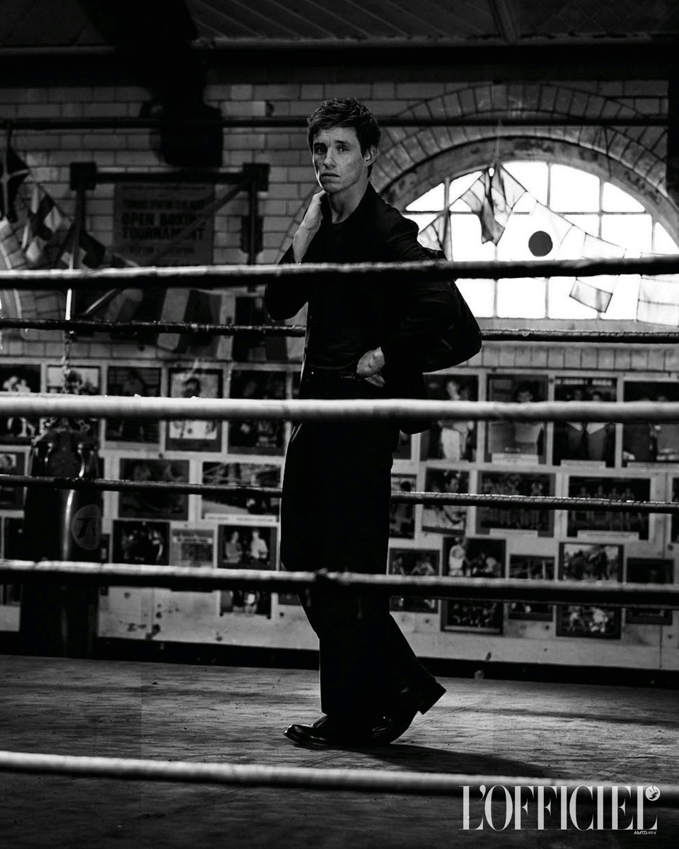 Wool blazer, THOM BROWNE; sweater, JIL SANDER BY LUCIE AND LUKE MEIER; trousers, MIU MIU; boots, PRADA; travel bag, PIERRE HARDY