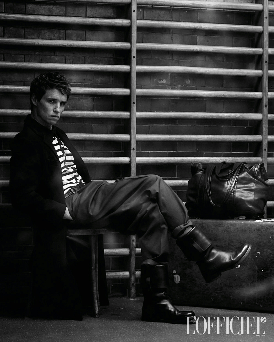 Coat and boots, PRADA; striped polo shirt and trousers, DOLCE & GABBANA; belt, VERSACE; travel bag, PIERRE HARDY; suitcase, GLOBETROTTER